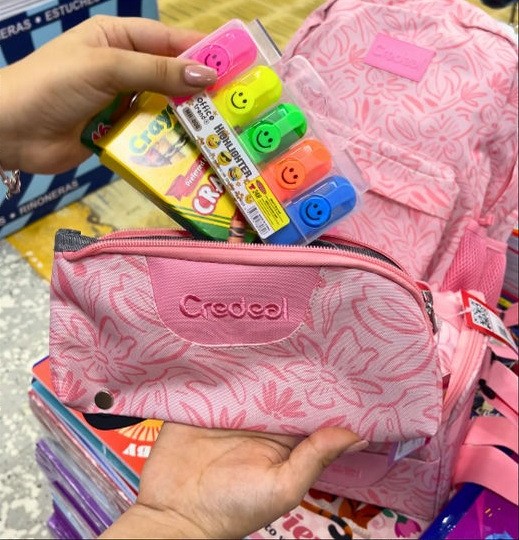 Mochila rosa Creddeal con crayones Stabilo en la mano