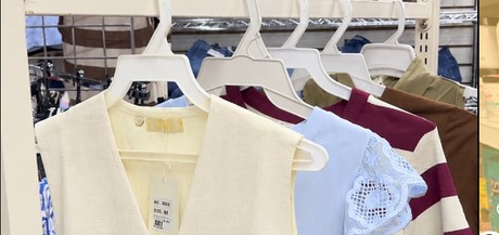 Blusas y vestidos claros en perchero de la sección de dama